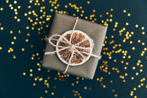 Geschenkdoos verpakt in ambachtelijk papier en versierd met gedroogde sinaasappelplak