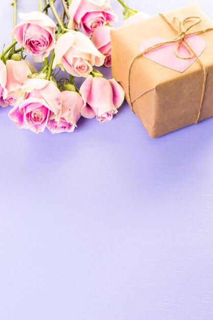 Geschenkdoos verpakt in gerecycled papier en versierd met roze hart met roze rozen.