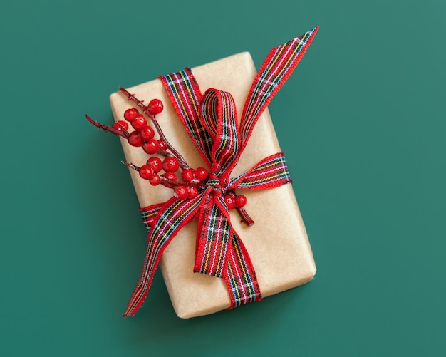 Geschenkdoos verpakt in karftpapier met rode strik op groen bovenaanzicht