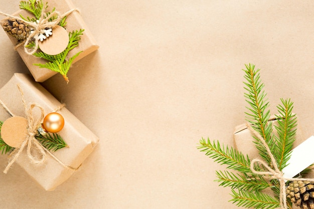 Geschenkdoos voor Kerstmis en Nieuwjaar in milieuvriendelijke materialen: kraftpapier, levende dennentakken, kegels, touw. Tags met mock up, natuurlijk decor, handgemaakt, DIY. Plat, achtergrond, frame, minimalisme
