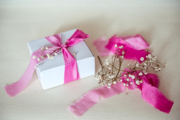 Geschenkdoosdecoratie met roze lint en droge bloemen