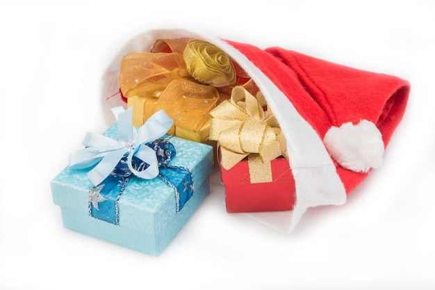 Geschenkdozen in rode kerstmuts op witte achtergrond