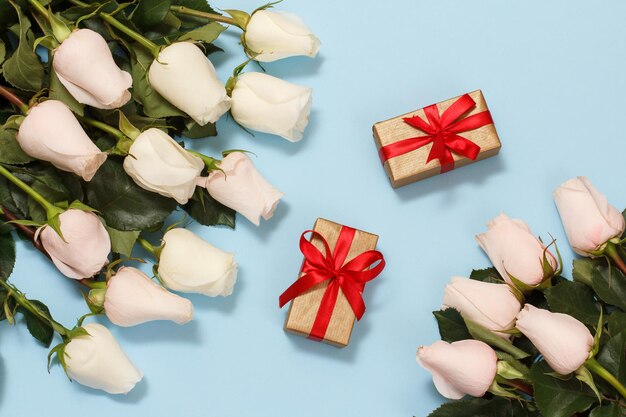 Geschenkdozen met mooie witte rozen op de blauwe achtergrond Concept van het geven van een geschenk op vakantie