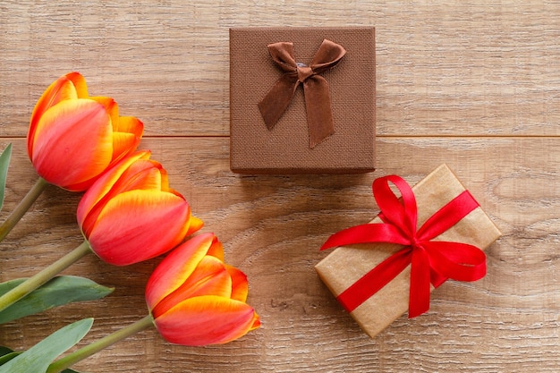 Geschenkdozen met rode tulpen op houten planken. Wenskaartconcept. Bovenaanzicht.