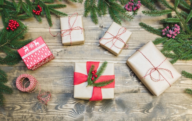 geschenken, hulst bessen en decoratie op een houten bord.