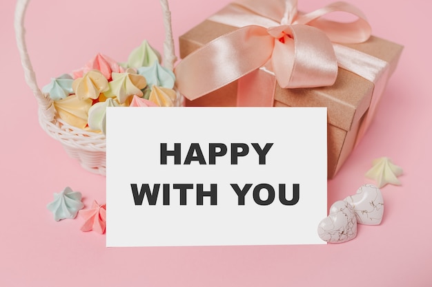 Geschenken met notitie brief op geïsoleerde roze achtergrond met snoep, liefde en valentijn concept met tekst blij met jou