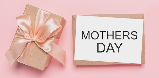 Geschenken met notitiebrief op geïsoleerde roze achtergrond, liefde en valentijnsconcept met tekst moederdag