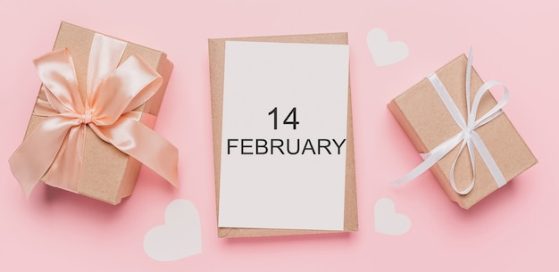 Geschenken met notitiebrief op geïsoleerde roze achtergrond, liefde en valentijnskaartconcept met tekst14 februari