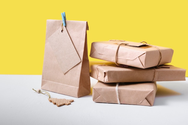 Geschenken verpakt in ecopapier op een gele achtergrond, zero waste lifestyle concept, verpakking voor doe-het-zelfcadeaus