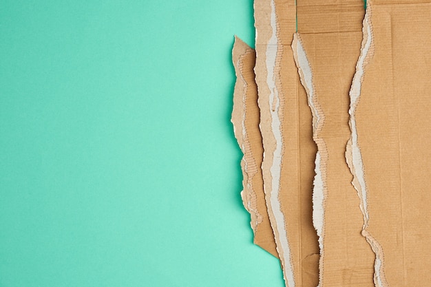 Foto gescheurde randen van golfkarton bruin papier op een groene achtergrond