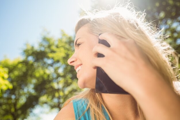 Foto geschikt blonde die op haar smartphone spreken