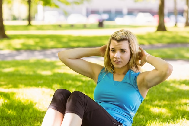 Foto geschikt blonde die zitten ups in het park doen