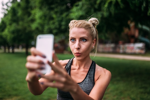 Geschikt meisje die grappig gezicht maken terwijl in openlucht het maken van een selfie.