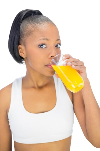 Geschikt vrouw het drinken glas jus d&#39;orange terwijl het bekijken camera