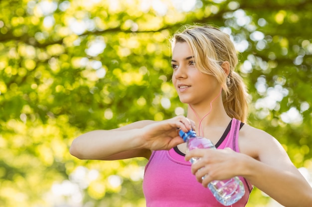 Foto geschikte blonde die haar waterfles houdt