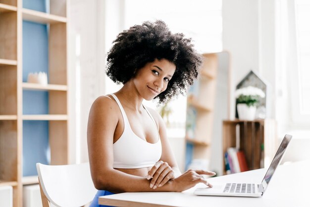 Geschikte jonge vrouw die laptop thuis gebruikt