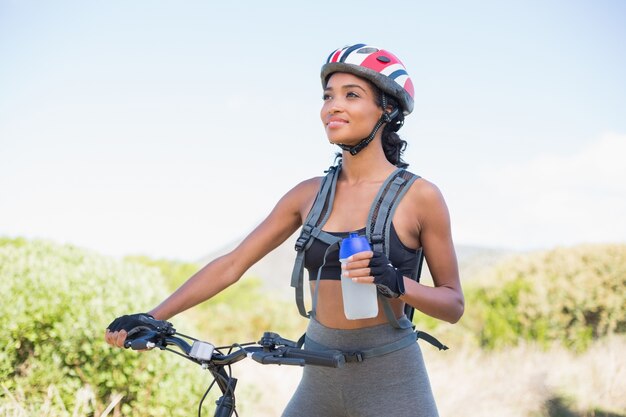 Geschikte vrouw die voor fietsrit gaat die waterfles houdt