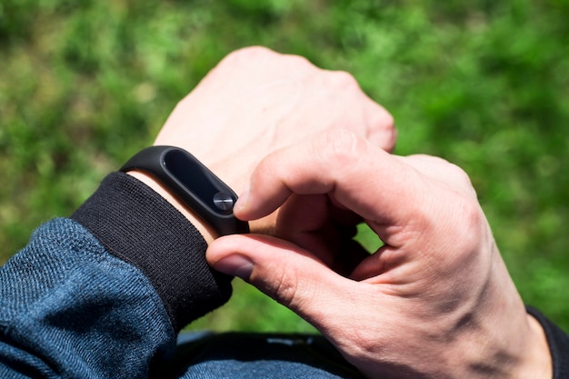 Geschiktheidsarmband of slim horloge op de hand van een man