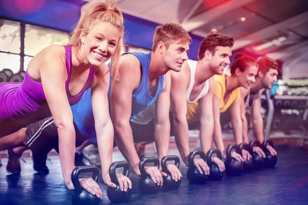 Foto geschiktheidsklasse in plankpositie met domoren in gymnastiek