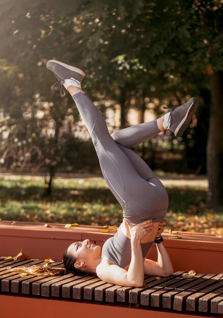 Geschiktheidsvrouw die yogaoefeningen doen die zich in de zomerpark uitrekken Sport Gezond concept