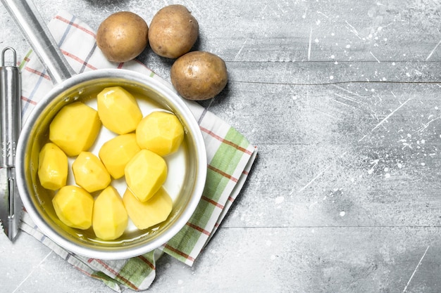 Geschilde aardappelen in een pan op servet