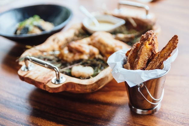 Geschilde frietjes geserveerd in een zilveren emmer als aperitief of bijgerecht.