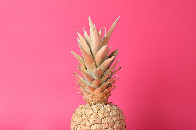 Foto geschilderde gouden ananas op roze achtergrond, ruimte voor tekst