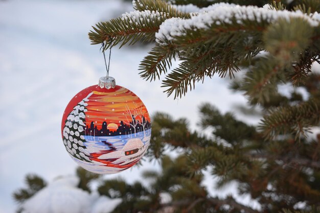 geschilderde kerstbol hangend aan dennenboomtak, close-up