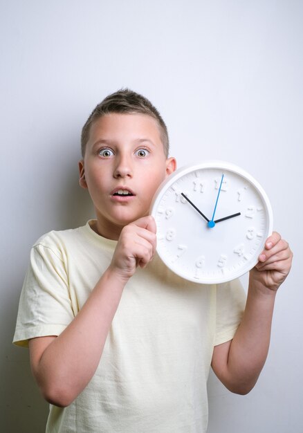 Geschokt grappige jongen met witte klok alarm kopie ruimte Kid geïsoleerd op witte achtergrond Schedul