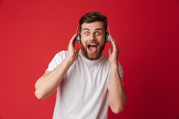 Geschokt jonge man geïsoleerd luisteren muziek met een koptelefoon.