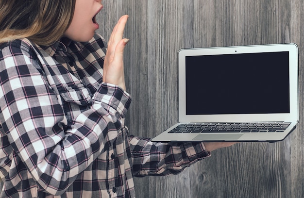 Foto geschokt vrouw in geruite overhemd lege scherm laptop