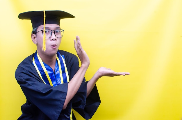 geschokte en verraste aziatische jongeman schreeuwt vrolijk om zijn afstuderen te vieren