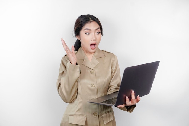 Geschokte overheidsmedewerker vrouw met haar laptop met haar mond wijd open PNS in khaki uniform