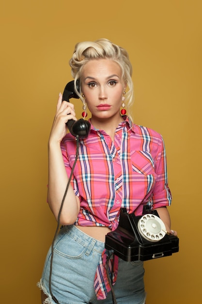 Foto geschokte pinup vrouw beantwoordt een telefoontje