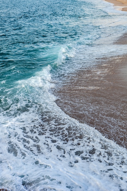 Geschuimde golven die in het strand breken
