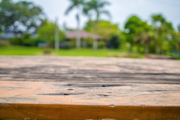 Foto geselecteerde focus lege houten tafel en uitzicht op groen bos wazige achtergrond met bokeh-afbeelding voor uw fotomontage of product lege bruine houten tafel en wazige achtergrond van kamperen