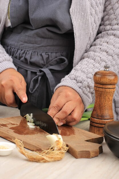 Geselecteerde Focus Vrouw die in de keuken werkt en de groenten hakt. Vrouwelijke lente-uitjes snijden voor salade. Close-up chef-kok snijden lente-uitjes.