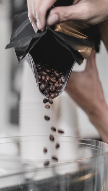 Foto geselecteerde koffiebonen in het koffiezetapparaat gieten