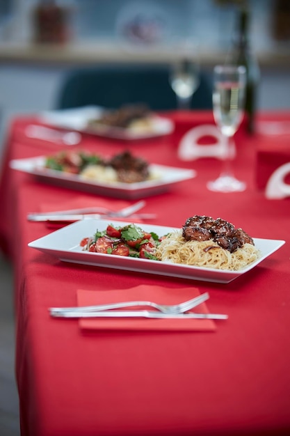 geserveerd tafel zoetzure kip met sesamzaadjes op een wit bord en glazen champagne