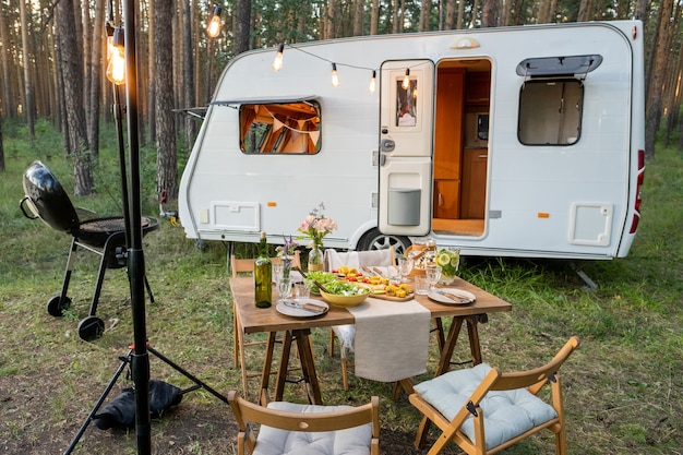 Geserveerde tafel met stoelen eromheen staand tegen huis op wieltjes