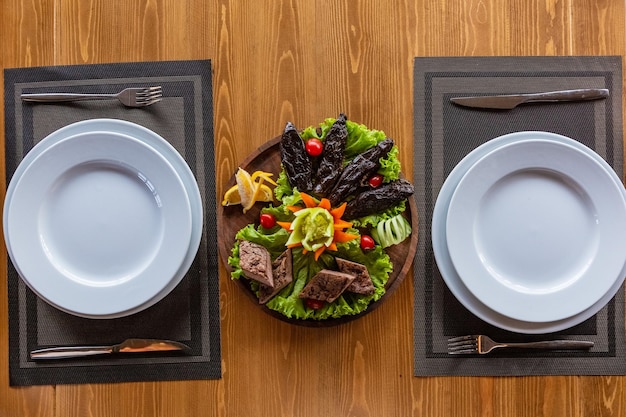 Geserveerde tafel voor twee, gebakken groenten en kiptabak