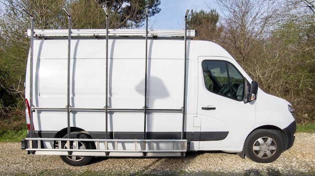 Foto gesloten bestelwagen wit met ladder aan zijkant transports glass voor vakman