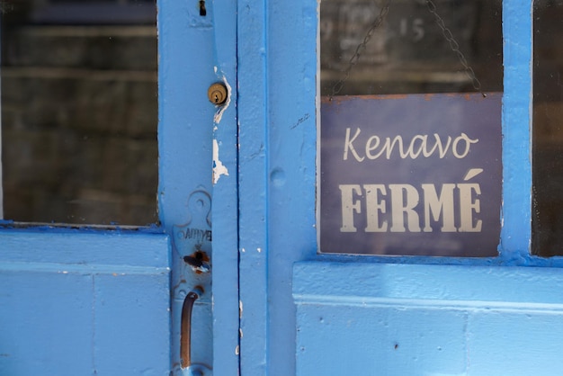 Gesloten Franse tekst betekent ferme en kenavo in de Bretagne-taal op het tekstbord van de deurwinkel op de Windows-winkel