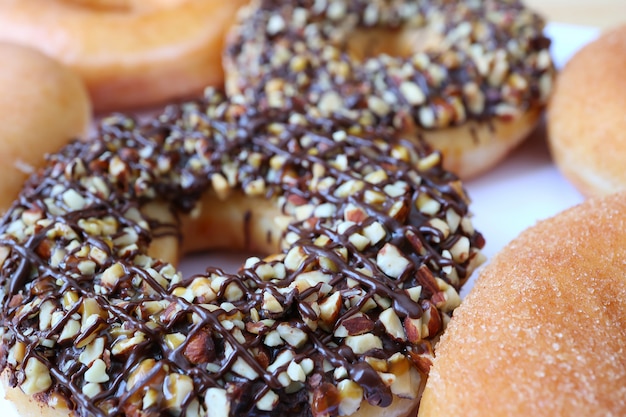 Gesloten heerlijke donut gegarneerd met chocolade en gehakte amandel, selectieve aandacht