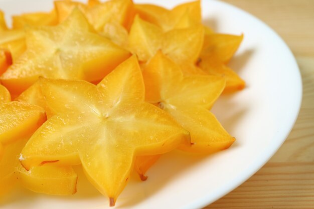 Gesloten levendige kleuren vers Star Fruit gesneden in vele stukken geserveerd op een witte plaat