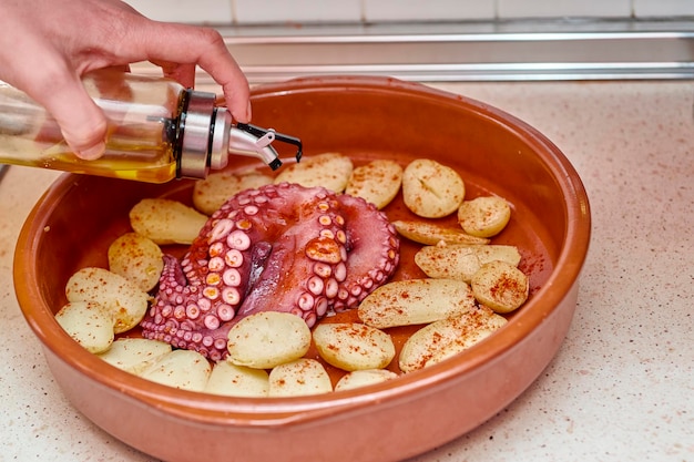 Gesloten schot koken gebakken octopus met aardappelen, olijfolie en paprika typisch en gezond eten