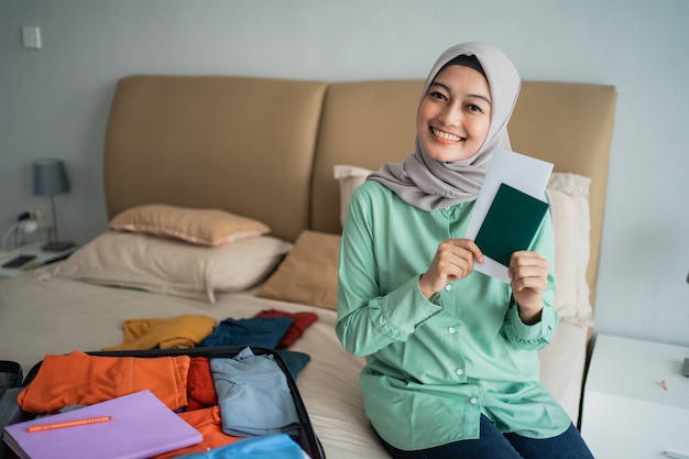 Gesluierde vrouw met een kaartje terwijl glimlacht