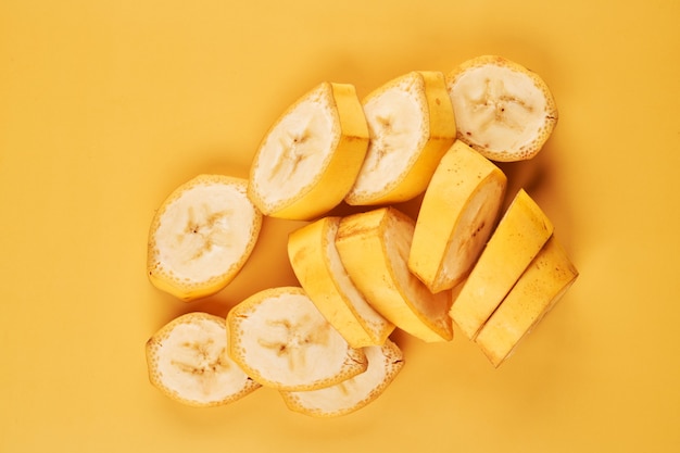 Gesneden bananen op gele achtergrond close-up, gezond dessertingrediënt