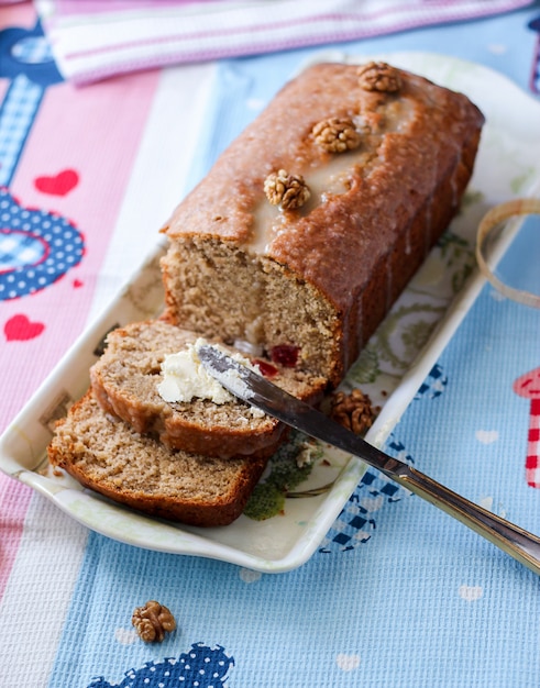 Gesneden bananenbrood notenbrood met walnoten, glazuur en roomkaas.