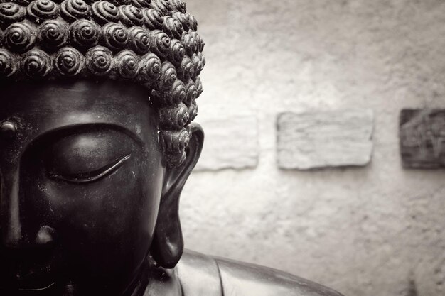 Foto gesneden beeld van boeddha-beeld tegen de muur
